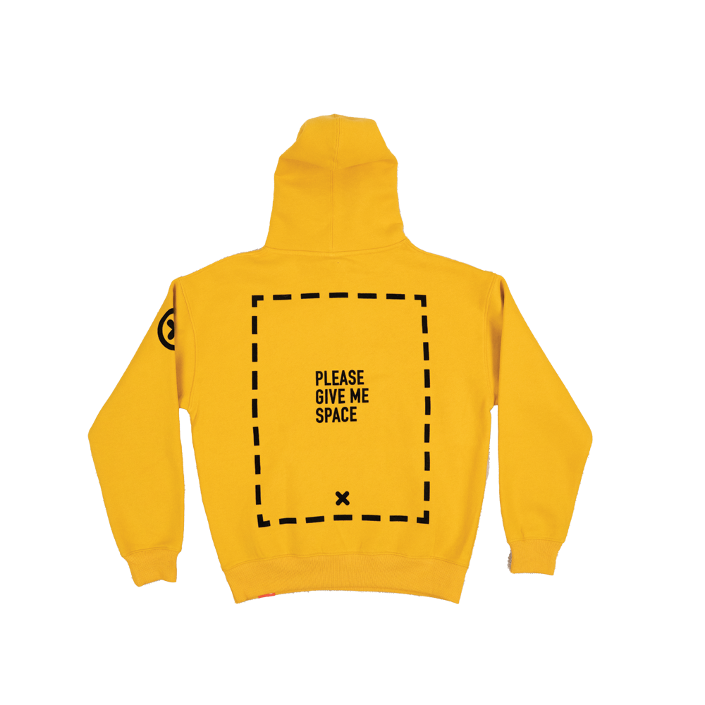 A yellow hoodie with a graphic of a dotted-line rectangle covering the majority of the back of the garment. In the center of the rectangle is the text "PLEASE GIVE ME SPACE". Towards the bottom of the inside of the rectangle is an "X". An "X" with a circle around it is on the left-shoulder of the hoodie.