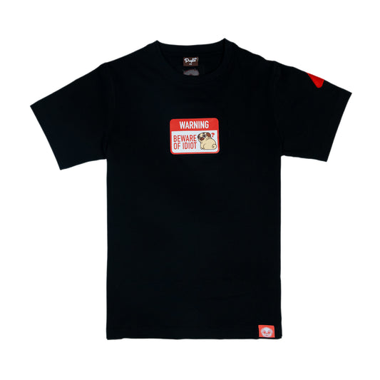 A black t-shirt with a graphic of a warning sign that says 'WARNING BEWARE OF PUGLIE' with an image of Puglie sitting down and looking confused. The graphic is in the center of the chest of the t-shirt. One of the sleeves is has a red embroidered warning sign (rounded triangle shape) with a white exclamation mark in the centre (it is hard to see). A red tag with a Puglie face design is stitched into the bottom hem of the shirt.