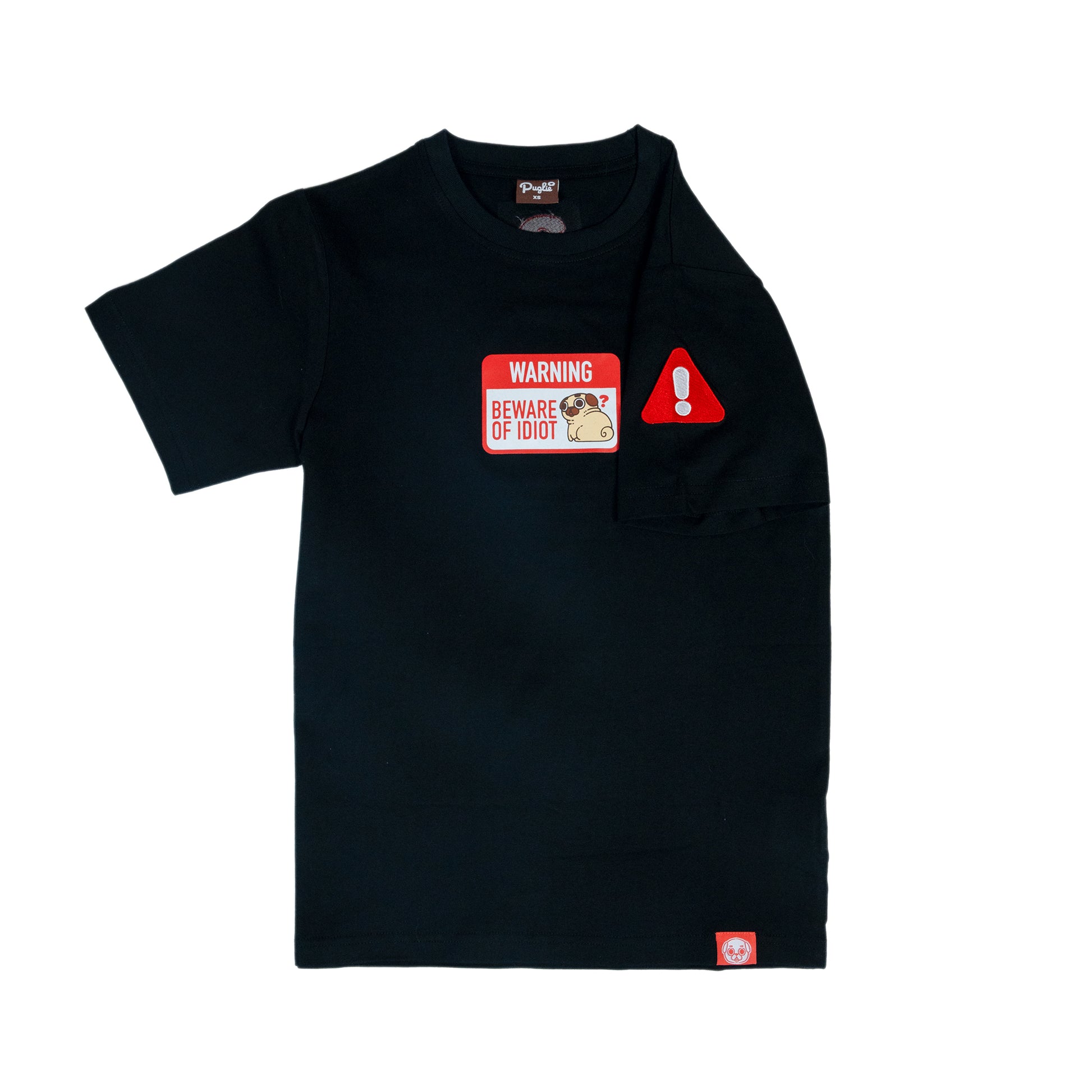 A black t-shirt with a graphic of a warning sign that says 'WARNING BEWARE OF PUGLIE' with an image of Puglie sitting down and looking confused. The graphic is in the center of the chest of the t-shirt. One of the sleeves is folded to display a red embroidered warning sign (rounded triangle shape) with a white exclamation mark in the centre. A red tag with a Puglie face design is stitched into the bottom hem of the shirt.