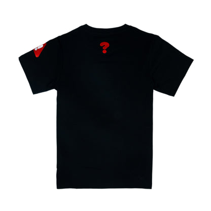 The back of a black t-shirt with an embroidered graphic of a question mark. The graphic is in the top-center of the back of the t-shirt. There is a red embroidered warning sign (rounded triangle shape) with a white exclamation mark in the centre on one sleeve.