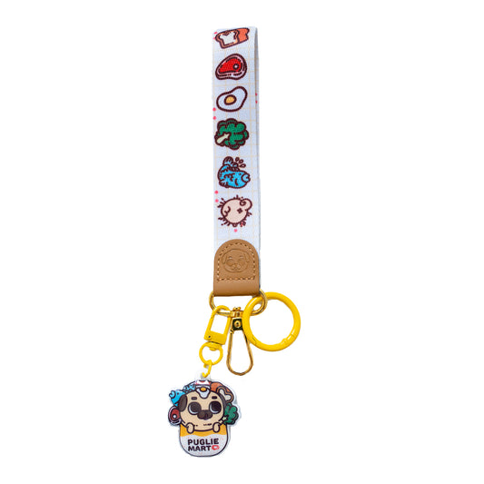 Keychain with a wrist strap featuring a design of many food items and one pug butt, with a leather-looking clasp embossed with a pug face. The leather-looking clasp is stitched to the wristlet and attached to a gold oval hoop, which has a yellow jump ring, a lobster clasp, and a hook clasp attached with a cute charm featuring Puglie in a bag with a bunch of food items surrounding him. The bag says "PUGLIE MART ❤️".